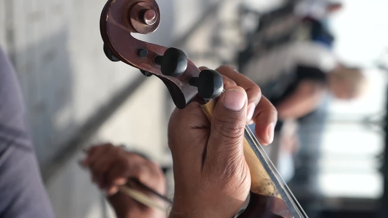 Close-up of hands playing a string instrument