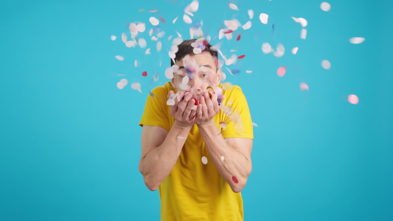 Man blowing confetti in celebration