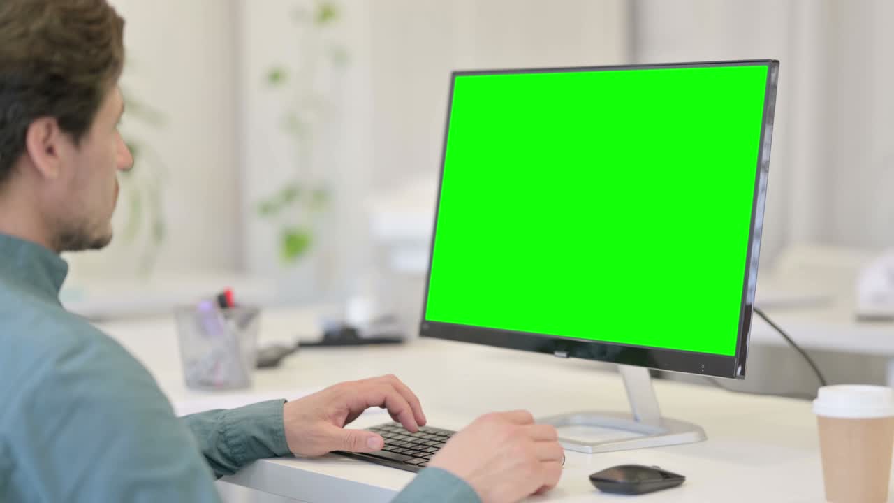 hombre usando el escritorio con pantalla clave de croma verde