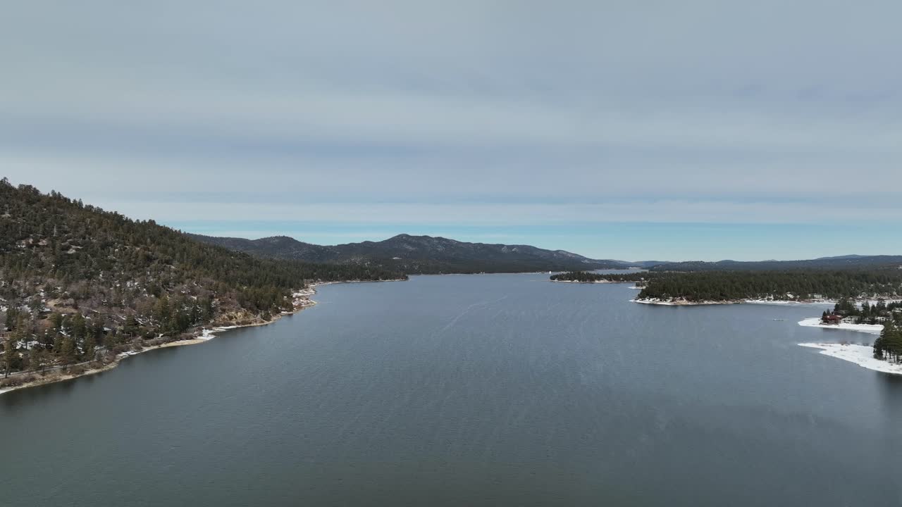 주변에 눈이 내리고 캘리포니아 숲이 있는 빅 베어 산 호수의 빠른 샷