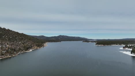 quick-shot-of-Big-Bear-Mountain-Lake-with-snow-around-it-and-woods-in-CA