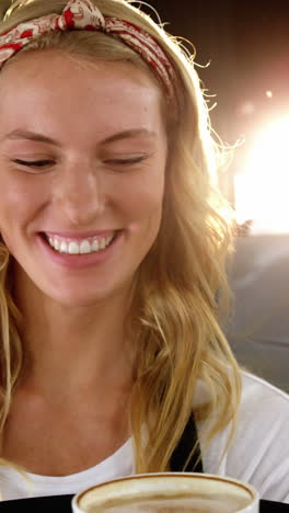 portrait of smiling waitress holding cup of coffee on serving tray