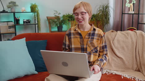 Woman-sitting-on-home-couch,-looking-at-camera,-making-video-conference-call-with-friends-or-family