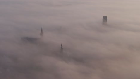 Side-panning-shot-of-center-of-Bolsward-with-low-clouds,-aerial