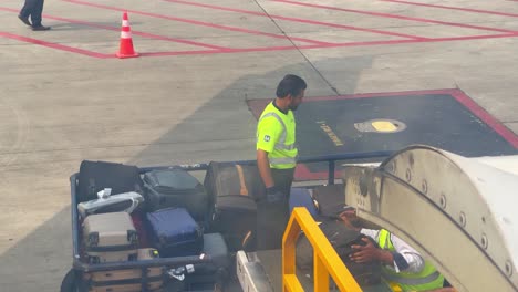 ground crew members efficiently manage passenger baggage on the airport tarmac.