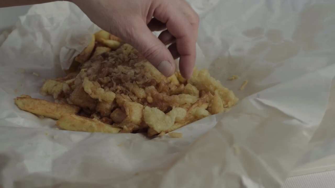 Hand eating fish and chips close up shot