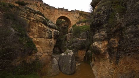 wide-angle-view-over-the-rocky-gorge-El-Tajo-river-and-Puente-Viejo,-Ronda,-Andalucia,-Spain