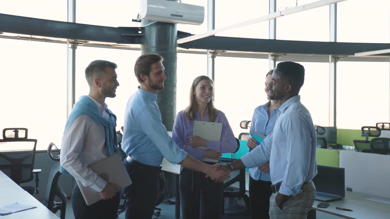 Professionisti d'affari diversi che si stringono la mano in un ufficio moderno.