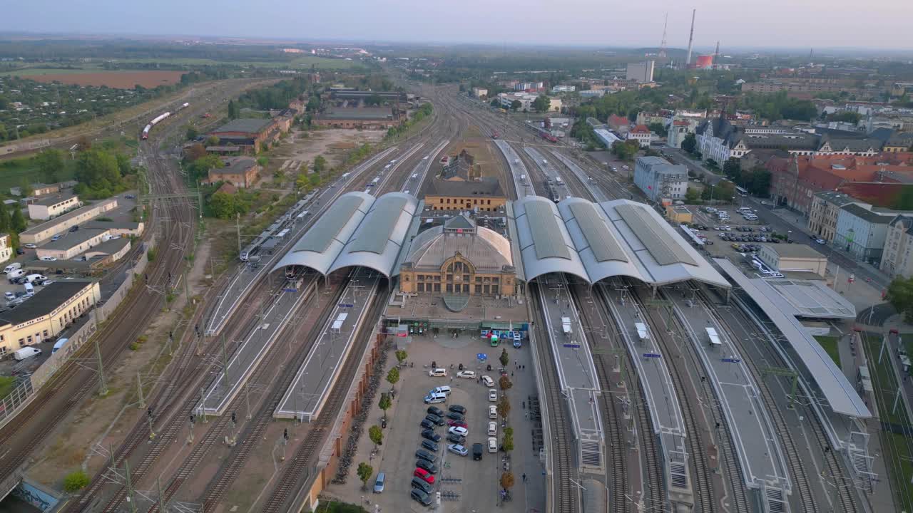 Aerial view of a modern train station with connecting tracks leading to suburbs and the city center. Nice aerial view flight drone top down Above view