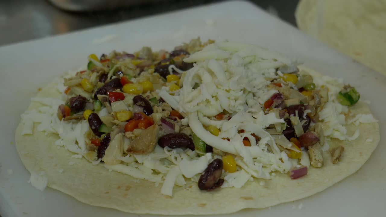 퀘사디아를 만들기 위해 치즈를 넣은 요리사