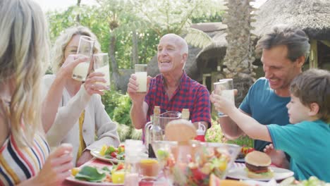 happy caucasian family having dinner and talking in garden