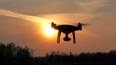 flying prosumer drone silhouette during sunset