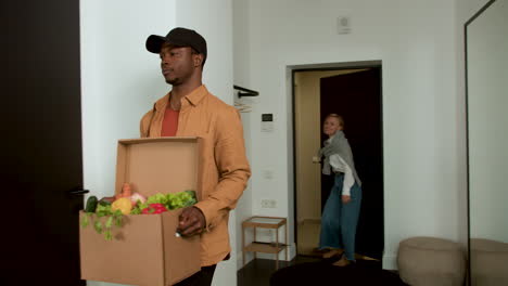 Woman receiving box of vegetables