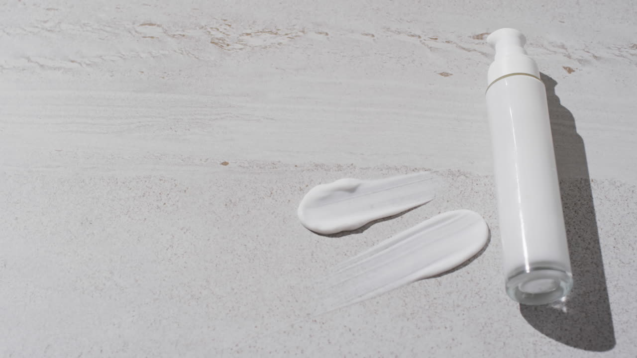 백색 배경에 복사 공간과 함께 미용 제품 튜브 및 크림 얼룩의 비디오