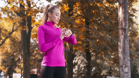 woman checking fitness watch in park