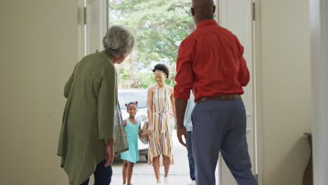 African-american-grandparents-embracing-and-greeting-their-smiling-family