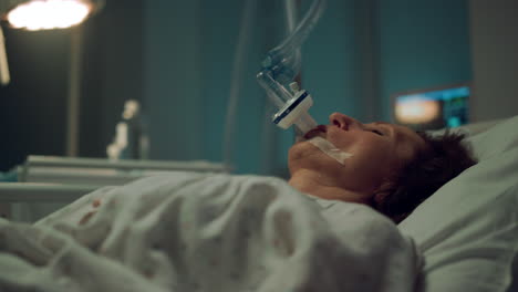 patient breathing oxygen mask in hospital closeup. terminally ill person clinic.