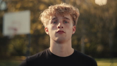 portrait of a young man at a basketball court