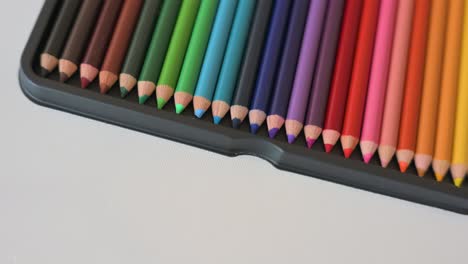 closeup of color pencils arranged in a rainbow pattern slowly rotating from above