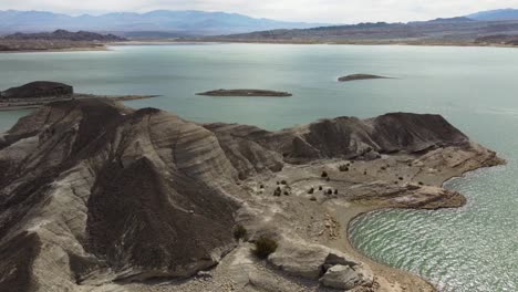 aerial flyover of rugged shoreline of potrerillos hydro dam reservoir