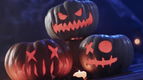 Video-of-halloween-carved-pumpkins-and-smoke-with-copy-space-on-blue-background