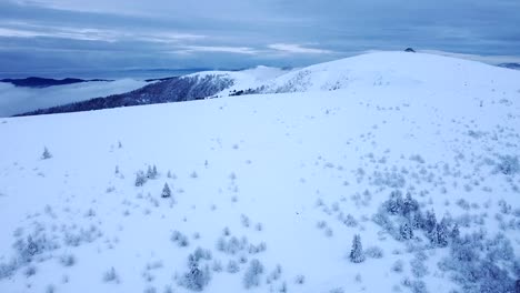 Aerial-winter-landscape-reveal-of-snow-capped-Hohneck-peak-with-clouds-in-Hautes-Vosges,-France