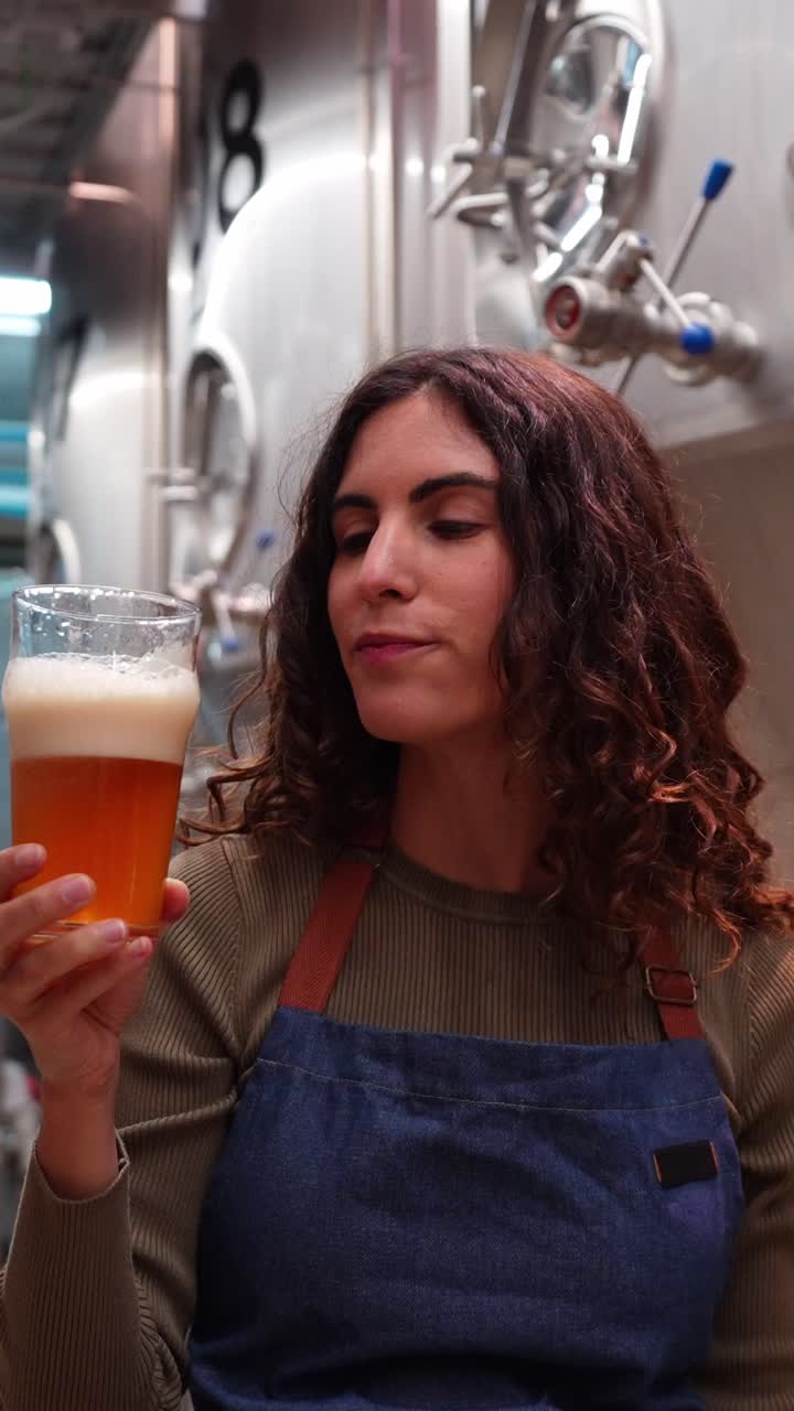 Donna che beve birra in un birrificio