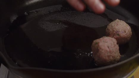 Añadiendo-Albóndigas-En-Una-Sartén-Caliente-Con-Aceite-De-Cocina