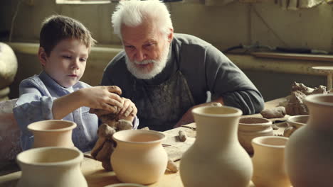 grandfather and grandson making pottery