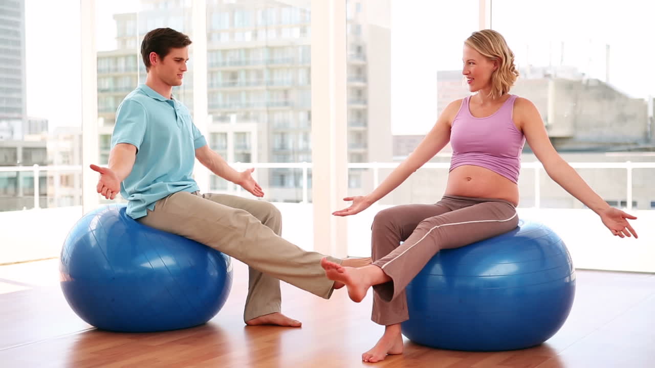 Pregnant woman doing yoga with a personal trainer