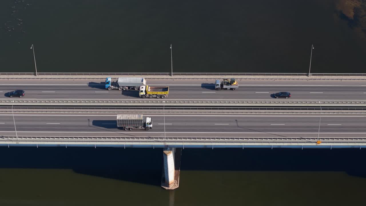 Aerial view of cars driving on a bridge over the Nemunas River in Kaunas, Lithuania, showcasing modern road infrastructure and flowing water below