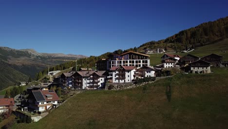 mountain hotel on a hill with houses and road and valley orbit going up