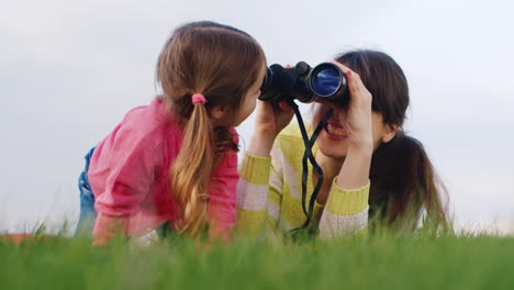 a young family spends time together in a spring garden mom looks through binoculars to the distance