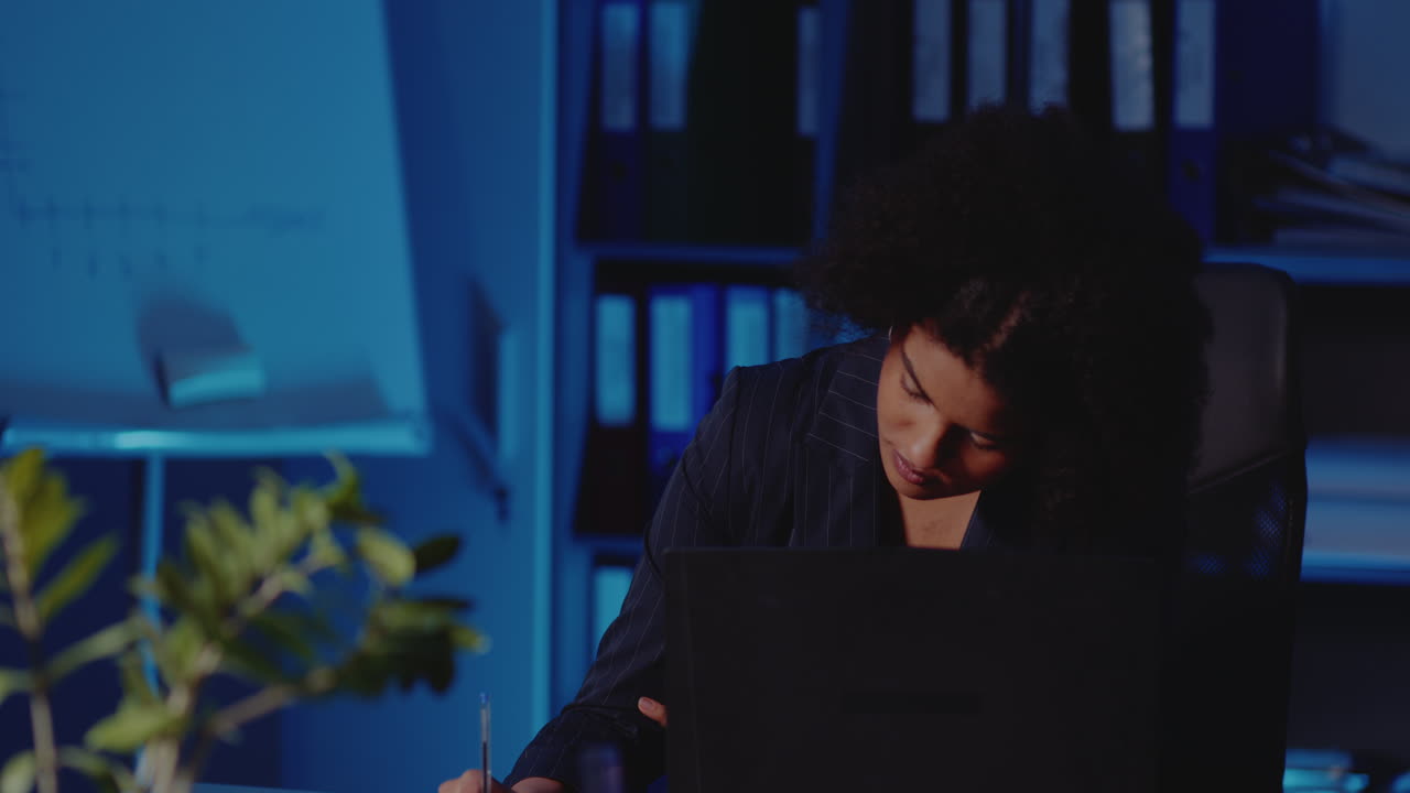 Mujer trabajando hasta tarde en la oficina