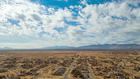 dynamic cloudscape time lapse over california city in the mojave desert - high altitude aerial view