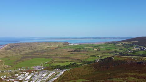 aerial view of coastal landscape with caravans and rolling hills