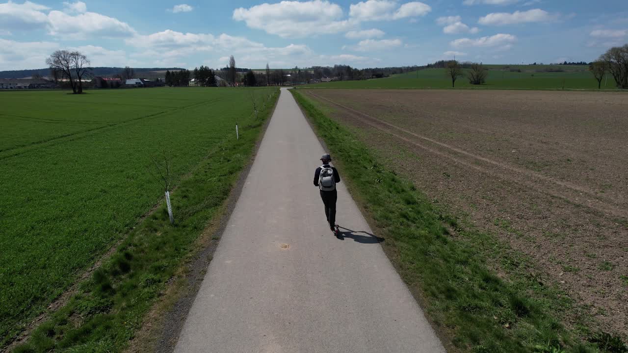 Overhead view of man riding an eletric scooter on a scenic rural road, near Svitavy in the Czech Republic