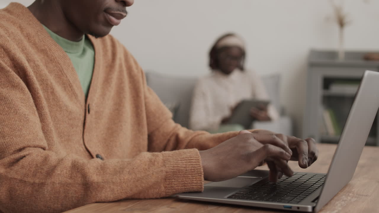 African Man Typing on Laptop Keyboard