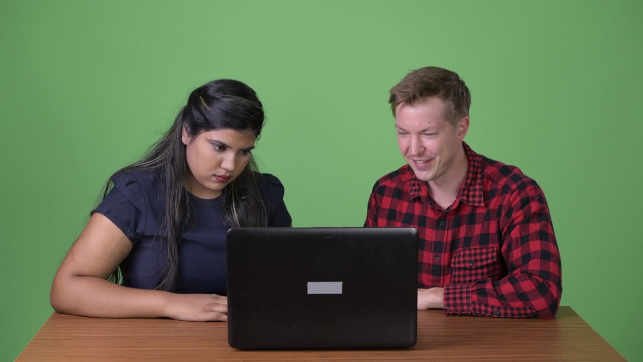 joven pareja de negocios multiétnica juntos contra un fondo verde