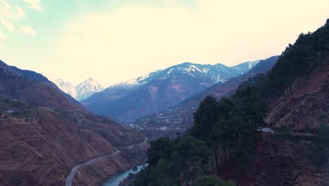 Valley-landscape-with-a-river,-and-snow-capped-mountains-in-the-background