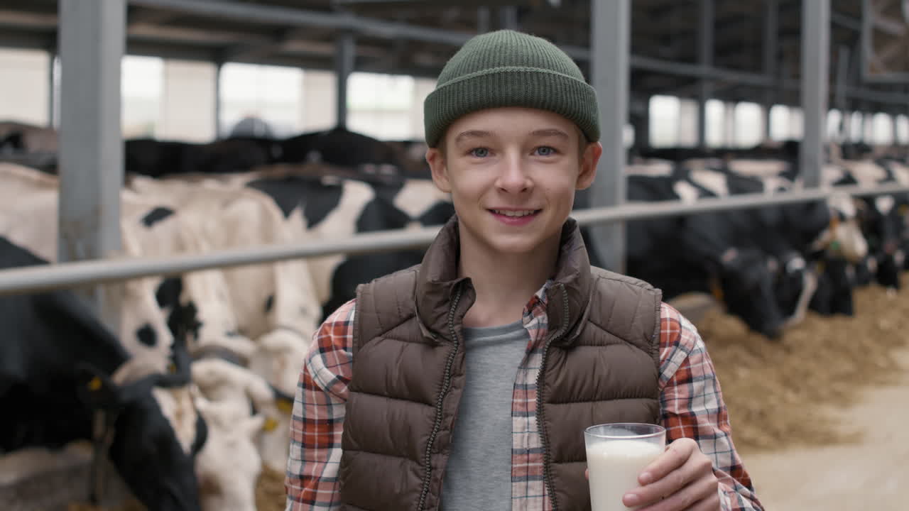 Teenage Boy Drinking Milk inside Dairy Farm