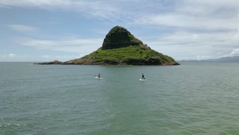 Paddleboarders paddling out to Chinaman&#039;s Hat