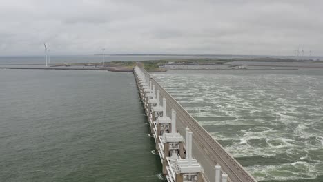 Toma-Aérea-De-Agua-Que-Pasa-A-Través-De-La-Barrera-De-Marejada-Ciclónica-Del-Este-De-Scheldt-En-Zelanda,-Los-Países-Bajos,-En-Un-Día-Tormentoso