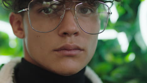 retrato de cerca de un joven atractivo estudiante con una expresión seria adolescente de la generación del milenio con gafas elegantes y de moda