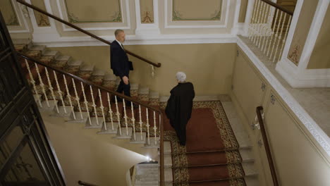 Men and woman meeting on the stairs of an old building