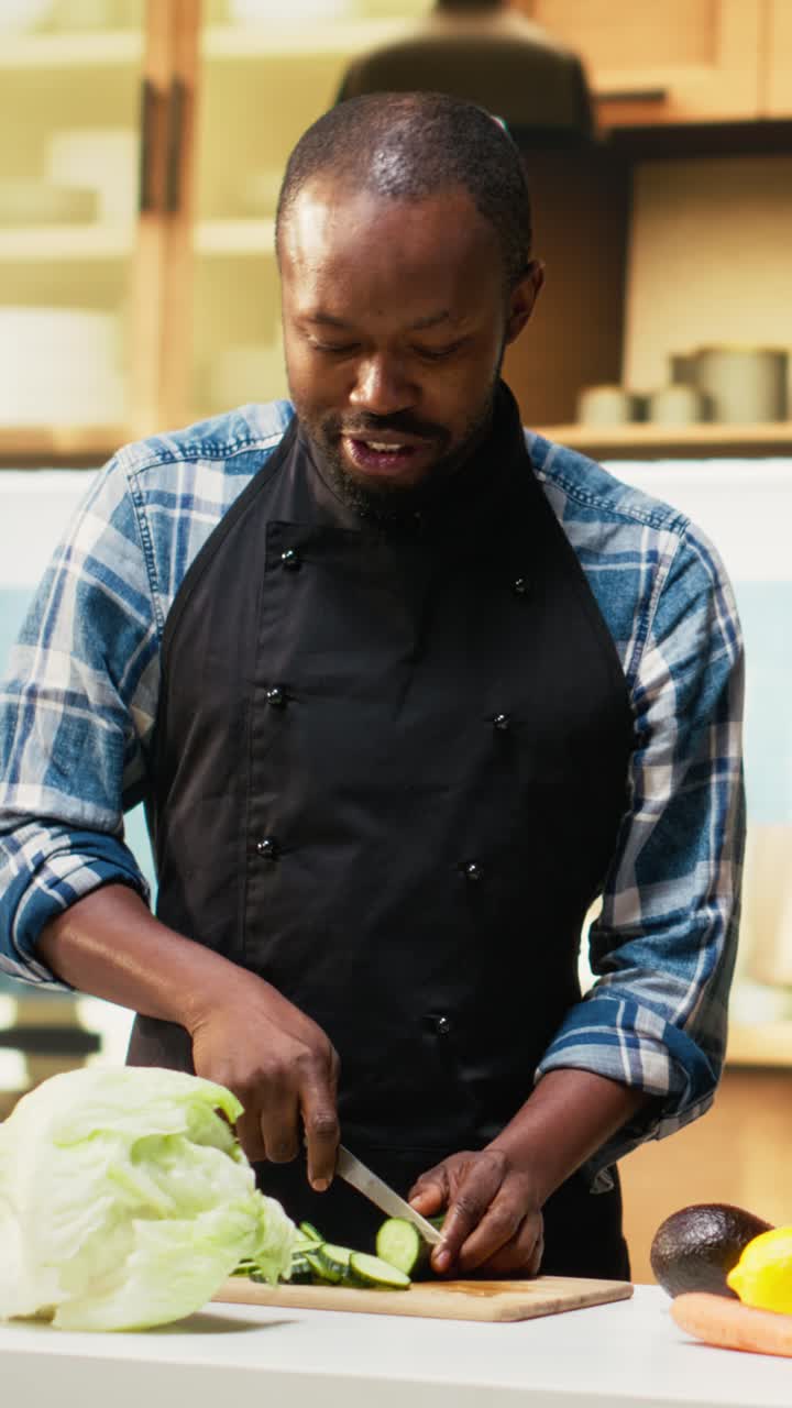 Vertical Video Black young people cutting fresh vegetables and adding in a bowl