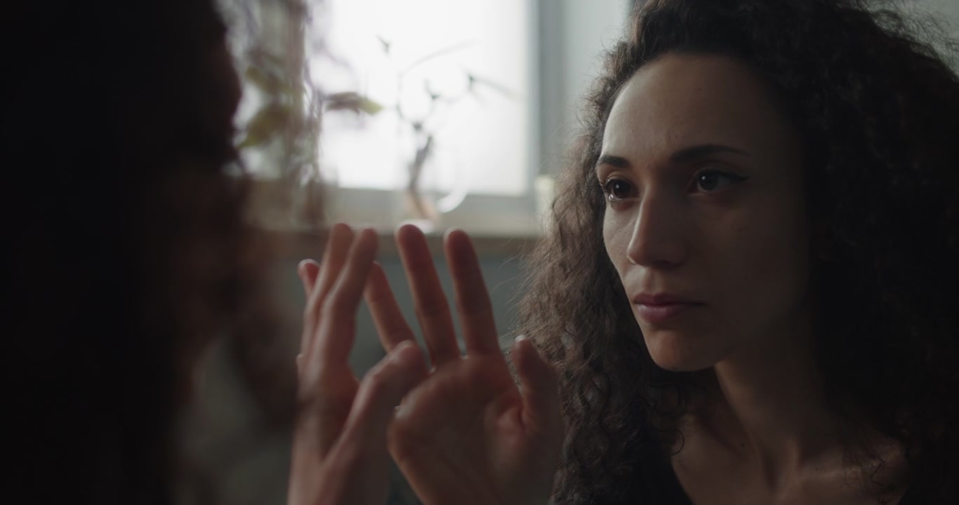 Woman reaching out hand in front of mirror
