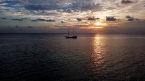 Vista-Aérea-De-Un-Velero-Con-Mástiles-Al-Atardecer-Amarrado-En-La-Laguna-Dhangethi,-Maldivas,-Océano-Índico