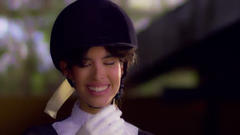 beautiful young woman in equestrian outfit smiling at camera