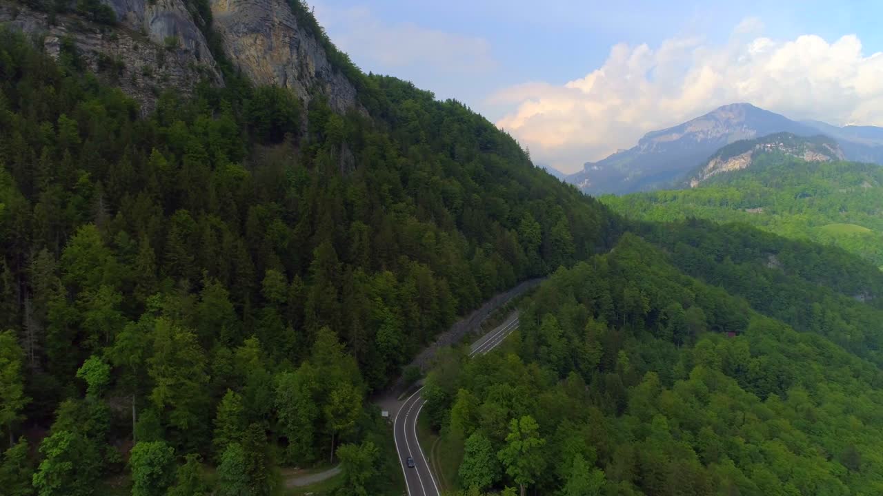 alpes suizos grúa de jib aérea disparada aviones no tripulados alpes montañas escarpadas empujan en el campo interior paisaje acantilado árboles de hoja perenne interlaken suiza